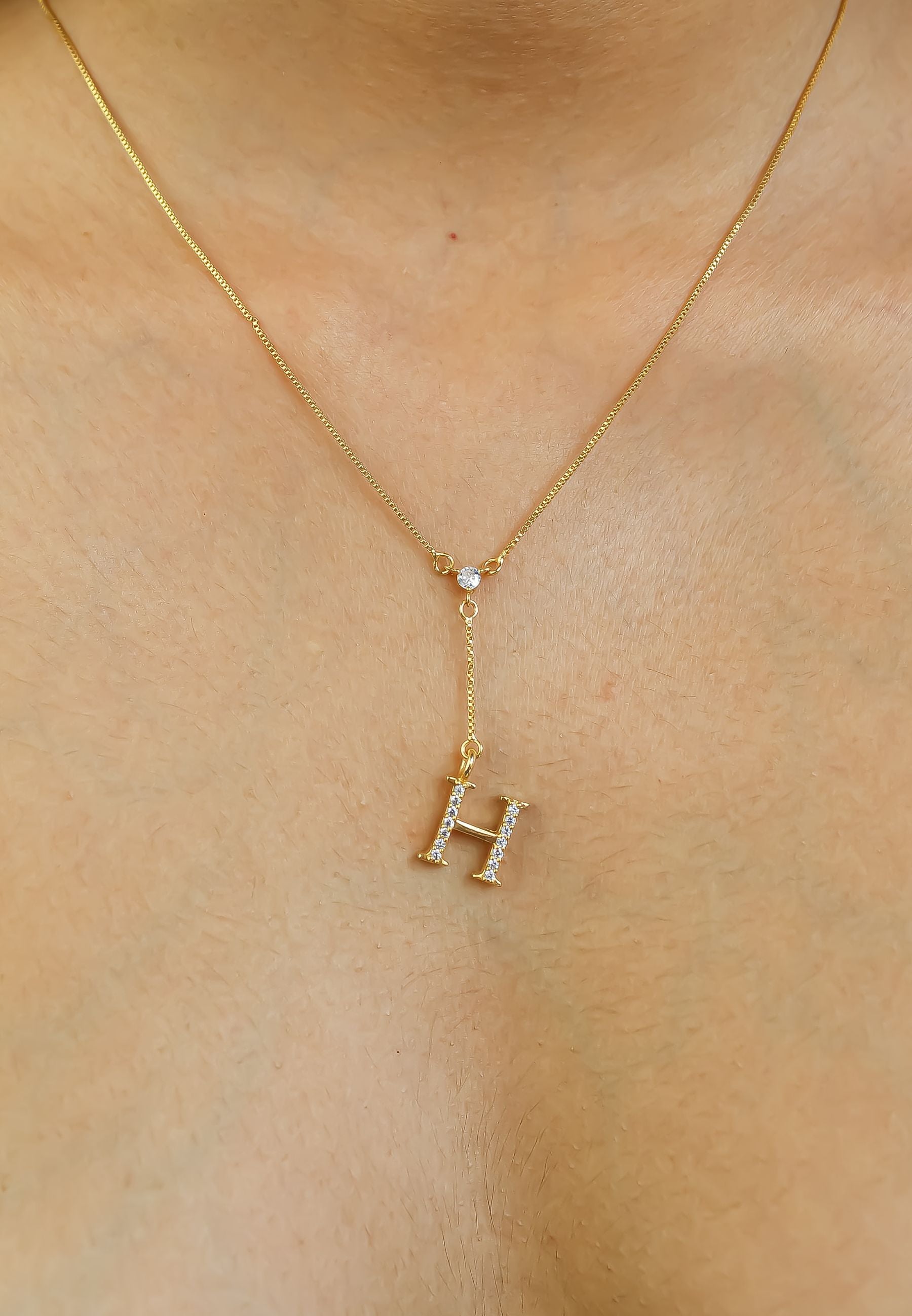 Elegant Golden Alphabet Necklace with zirconia stones, showcasing a personalized initial, perfect for layering or gifting.