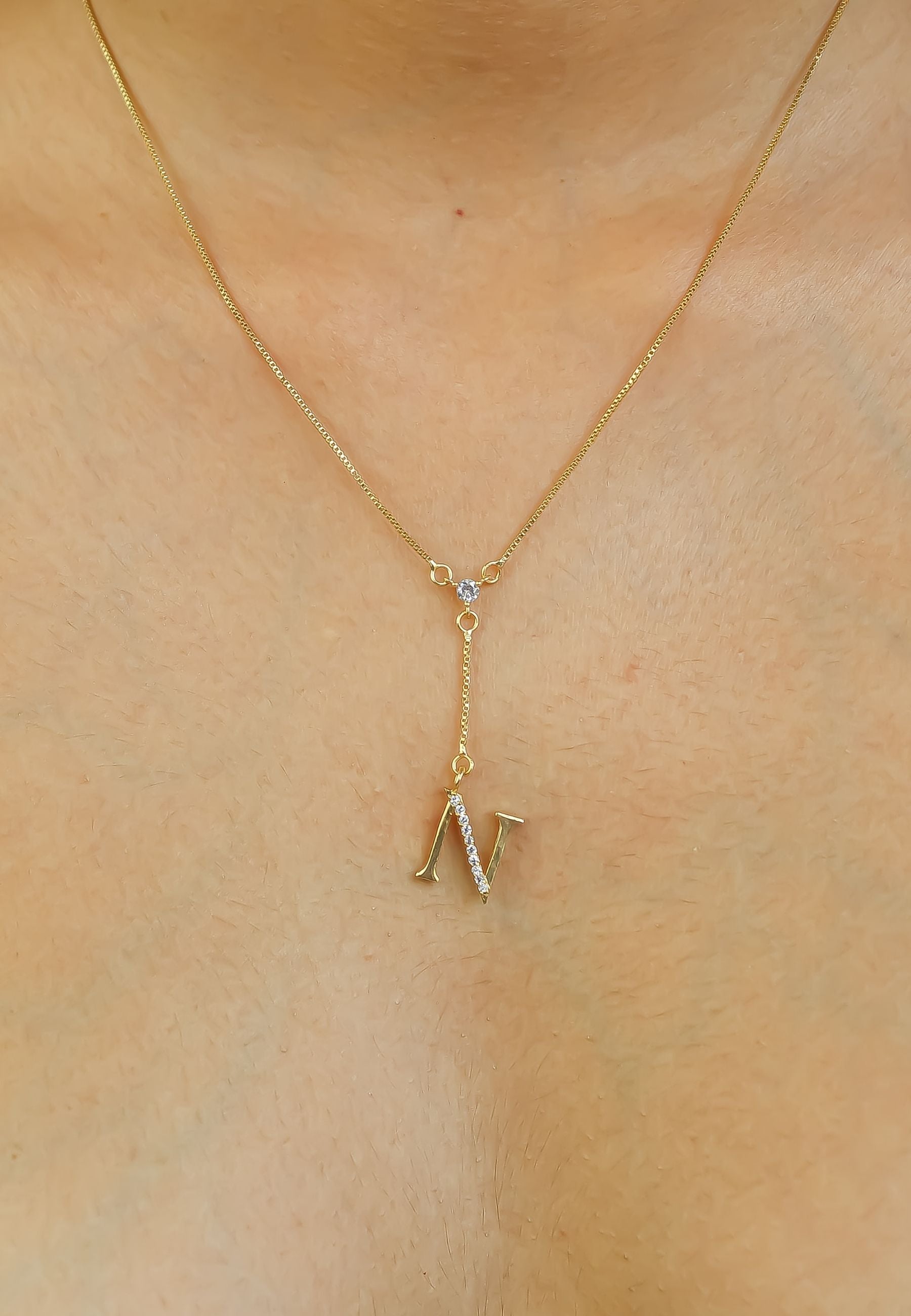 Elegant Golden Alphabet Necklace with zirconia stones, showcasing a personalized initial, perfect for layering or gifting.