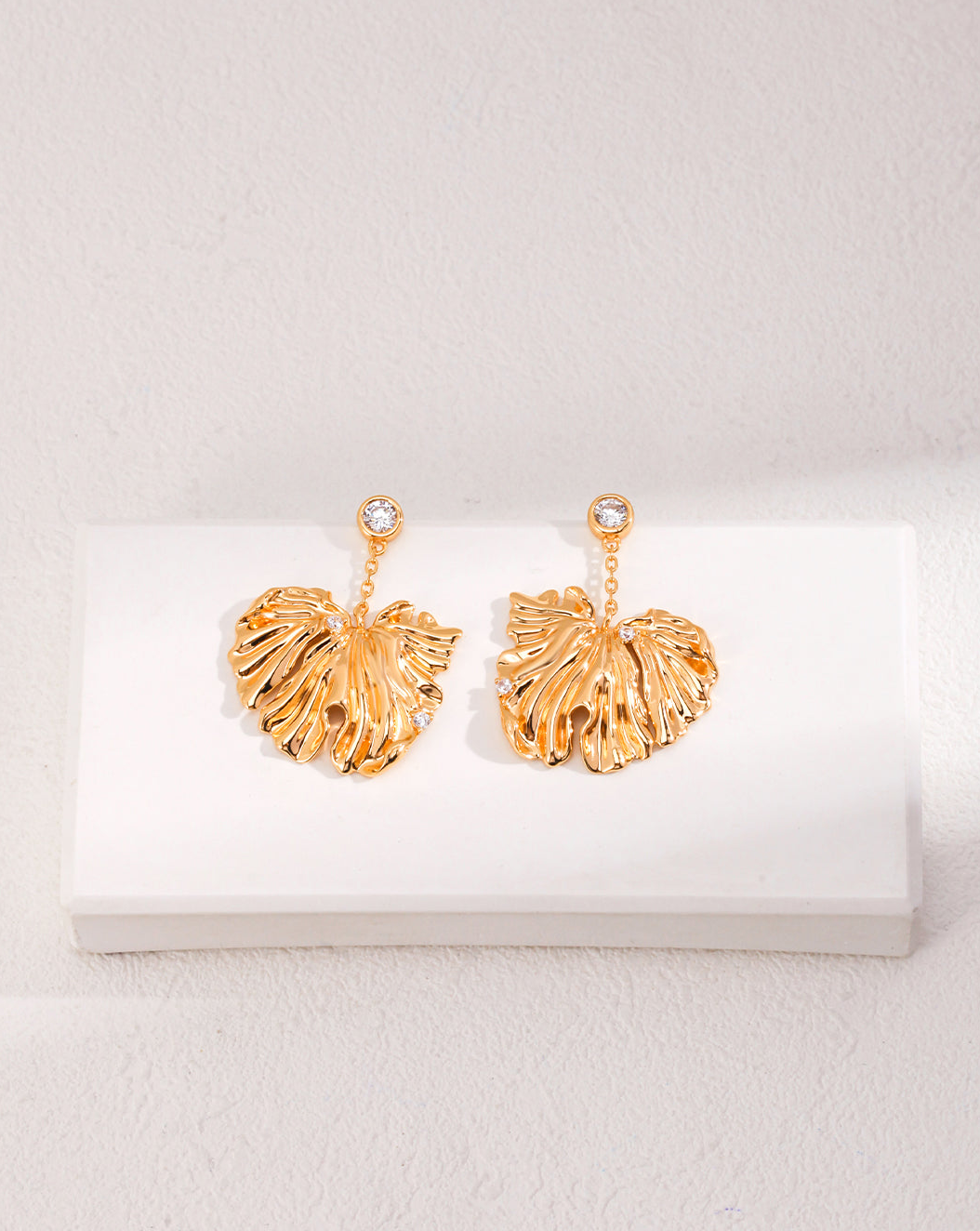 Golden Grove Silver Zircon Leaf Pendant Earrings featuring intricate leaf design and shimmering zircon stones in vintage gold color.