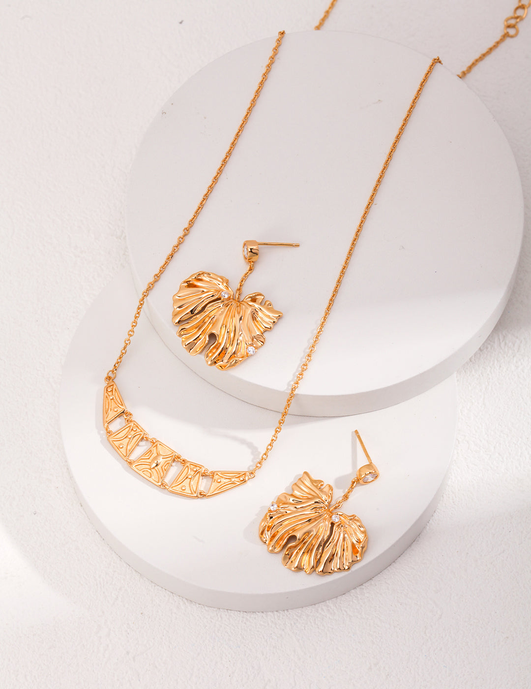 Golden Grove Silver Zircon Leaf Pendant Earrings featuring intricate leaf design and shimmering zircon stones in vintage gold color.