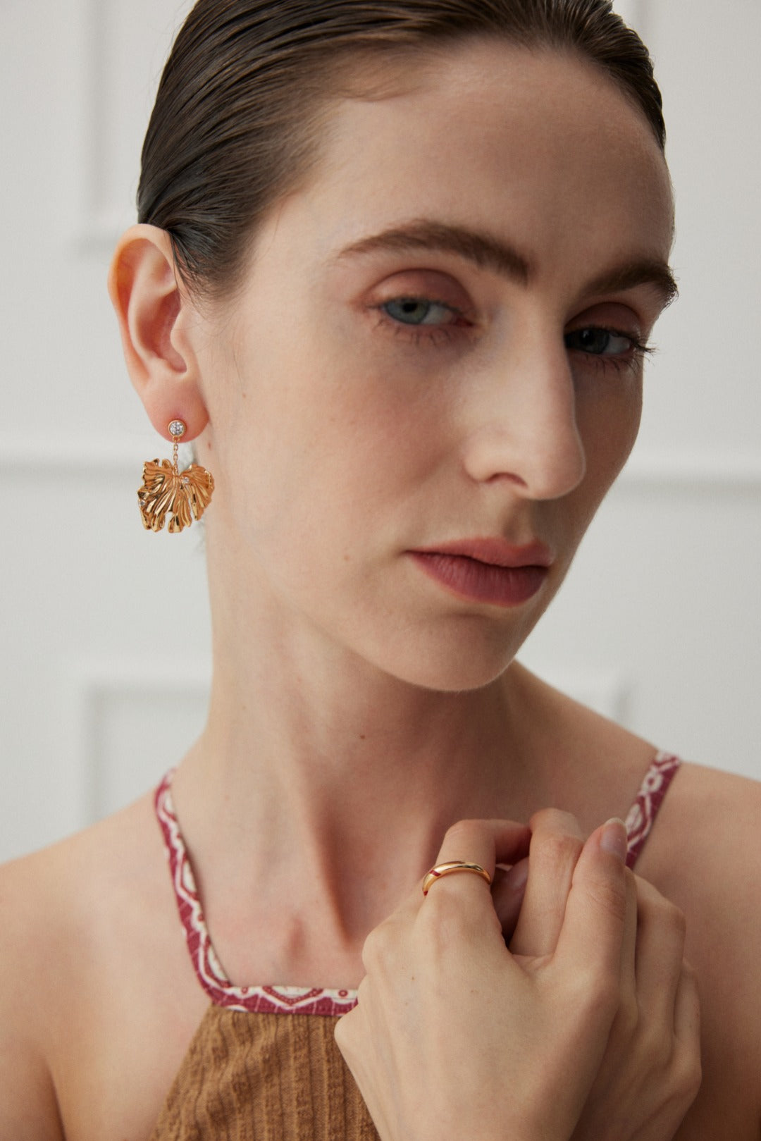 Golden Grove Silver Zircon Leaf Pendant Earrings featuring intricate leaf design and shimmering zircon stones in vintage gold color.
