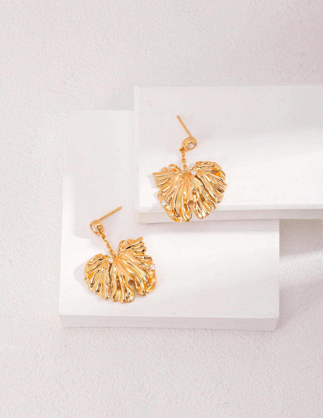 Golden Grove Silver Zircon Leaf Pendant Earrings featuring intricate leaf design and shimmering zircon stones in vintage gold color.