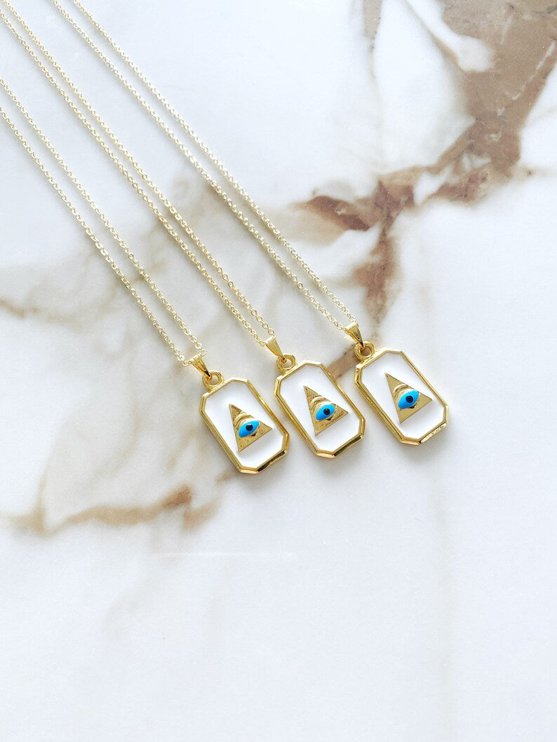 Grecee Evil Eye Necklace featuring a white enamel pendant on a gold chain, symbolizing protection and style.