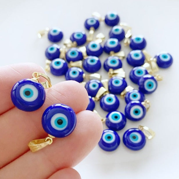 A collection of blue handmade Greek Evil Eye beads made from Murano glass, showcasing their vibrant color and unique design.