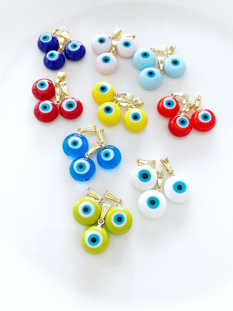 A collection of blue handmade Greek Evil Eye beads made from Murano glass, showcasing their vibrant color and unique design.