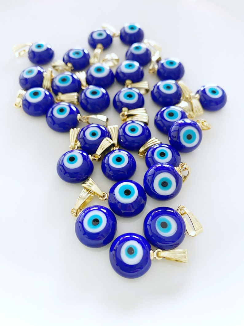 A collection of blue handmade Greek Evil Eye beads made from Murano glass, showcasing their vibrant color and unique design.