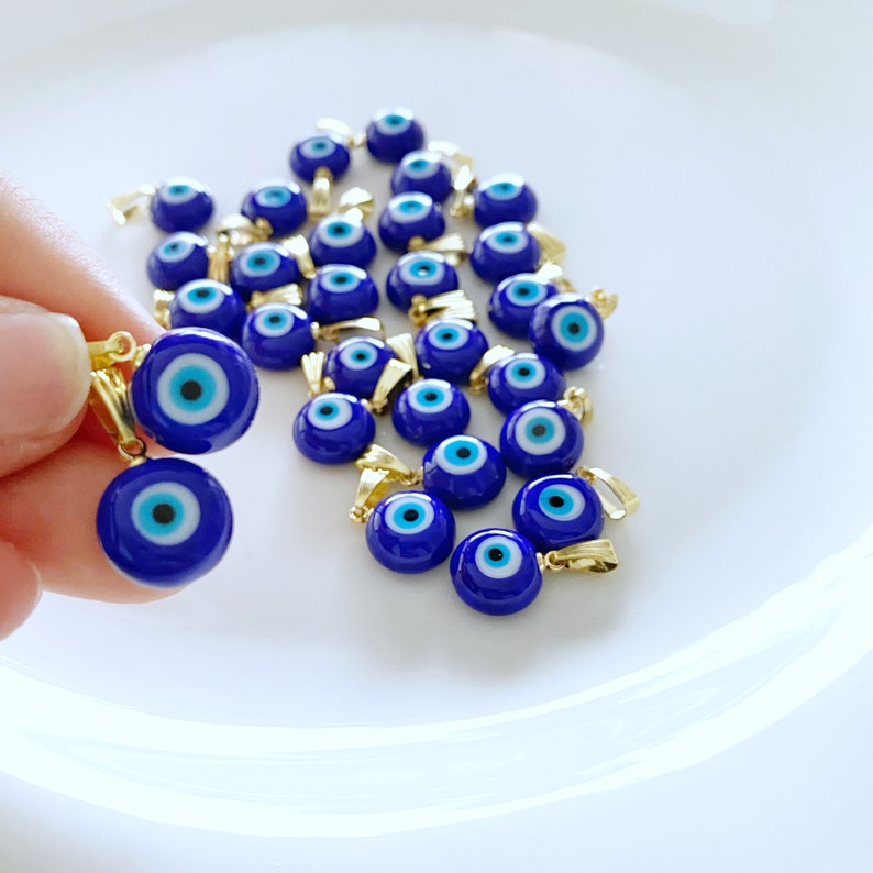 A collection of blue handmade Greek Evil Eye beads made from Murano glass, showcasing their vibrant color and unique design.