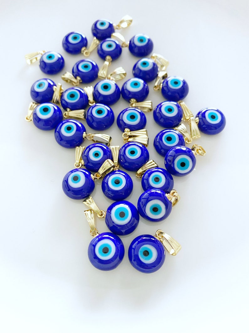 A collection of blue handmade Greek Evil Eye beads made from Murano glass, showcasing their vibrant color and unique design.