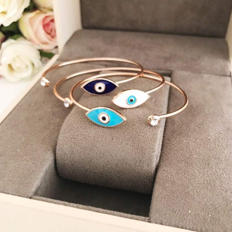 Greek Evil Eye Bracelet featuring a movable blue evil eye bead on a stainless steel bangle, available in multiple colors.