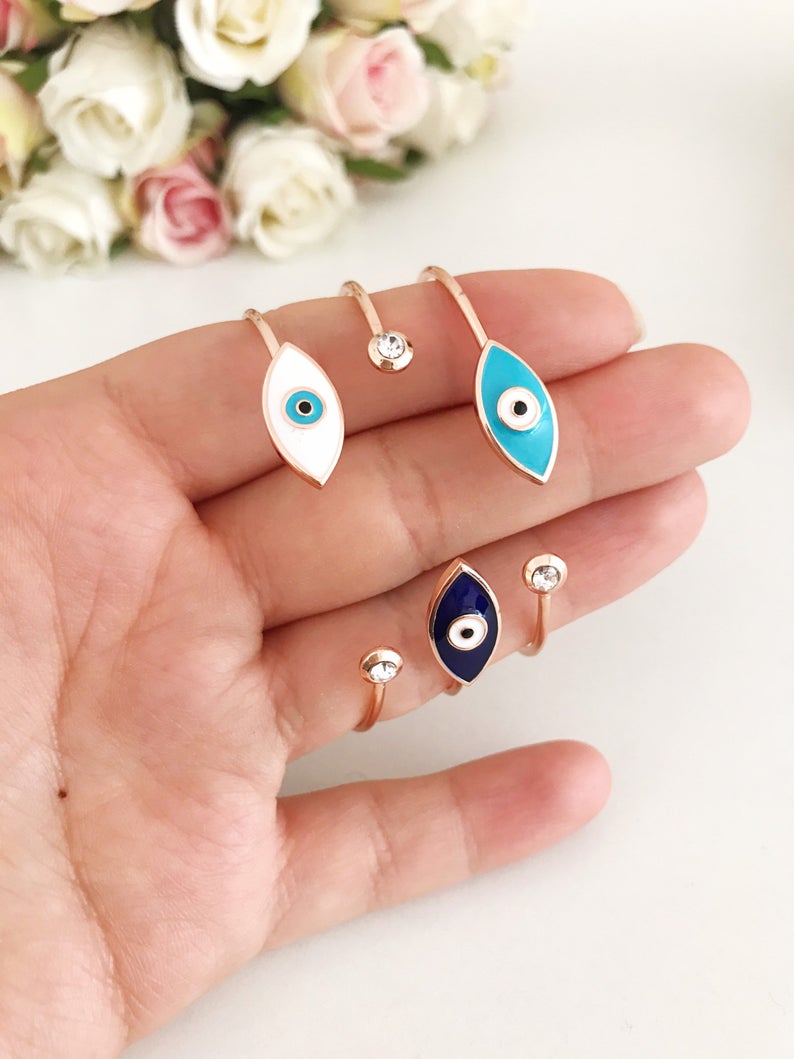 Greek Evil Eye Bracelet featuring a movable blue evil eye bead on a stainless steel bangle, available in multiple colors.