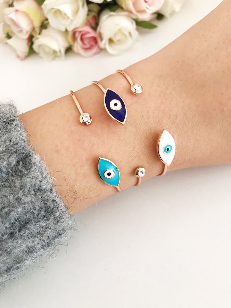 Greek Evil Eye Bracelet featuring a movable blue evil eye bead on a stainless steel bangle, available in multiple colors.