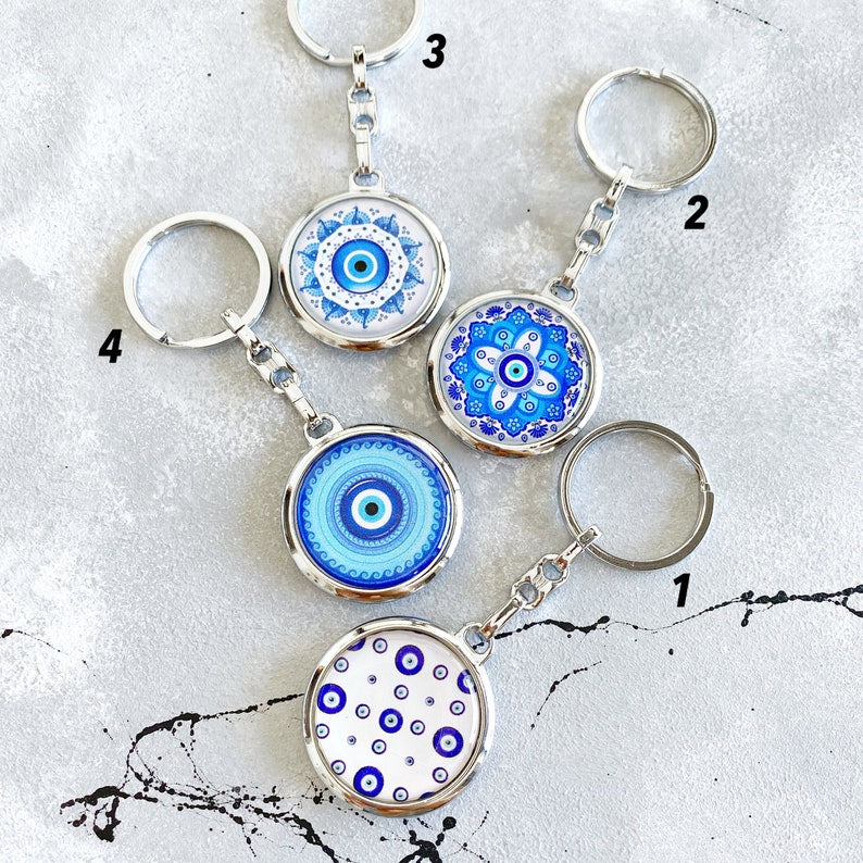 A beautiful Greek Evil Eye Key Chain featuring a blue enamel design, symbolizing protection and good luck, attached to a silver keyring.