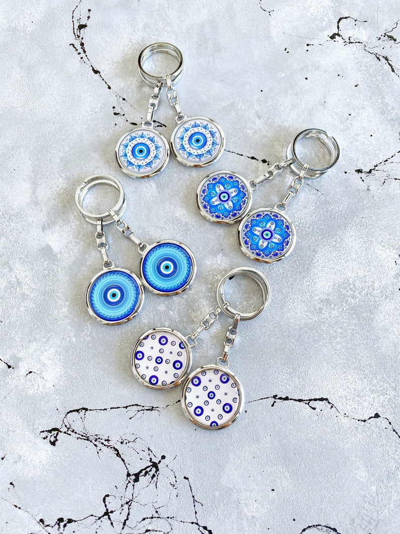 A beautiful Greek Evil Eye Key Chain featuring a blue enamel design, symbolizing protection and good luck, attached to a silver keyring.