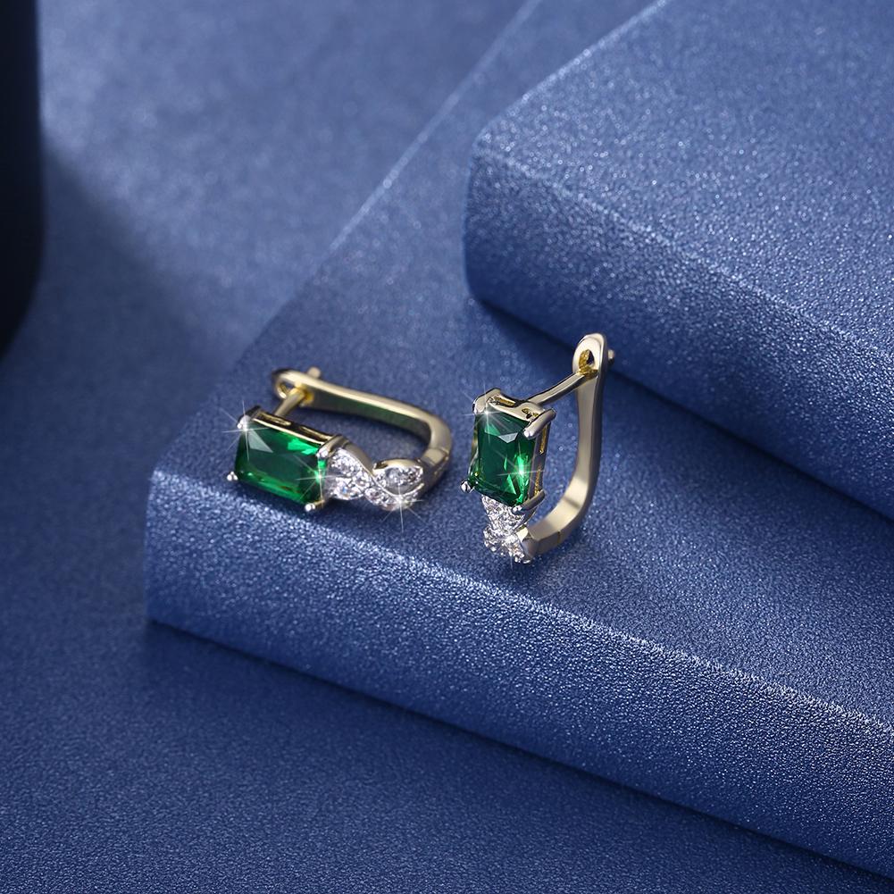 Elegant Green Emerald Cut Twisted Earrings featuring certified crystals and 18K gold plating, showcasing a unique twisted design.