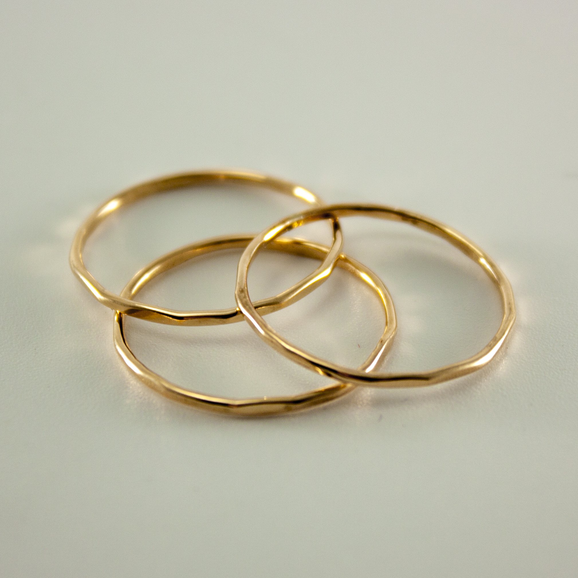 A stylish stack of three slim hammered rings made from 14k gold filled material, showcasing a minimalist design perfect for everyday wear.