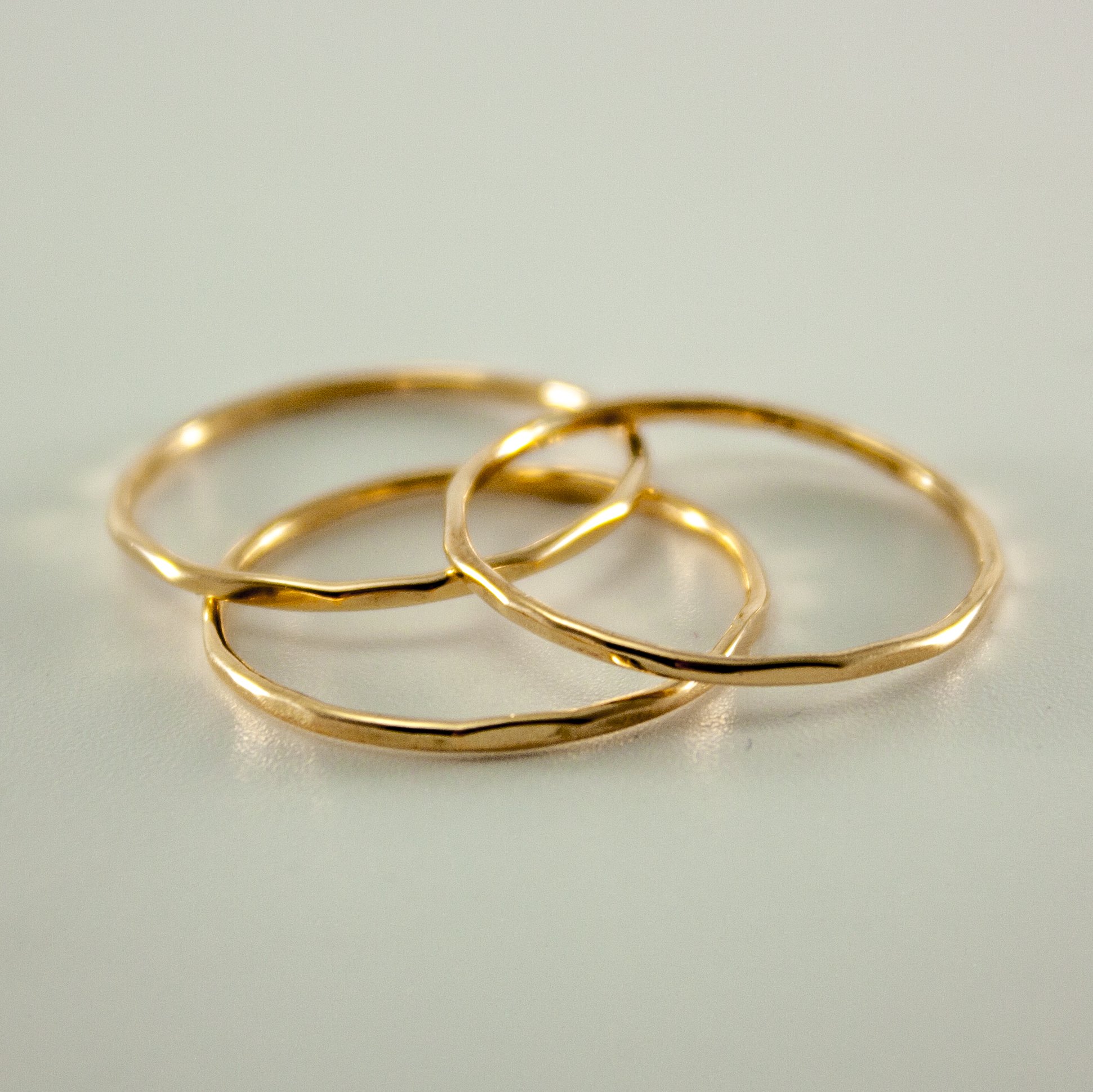A stylish stack of three slim hammered rings made from 14k gold filled material, showcasing a minimalist design perfect for everyday wear.