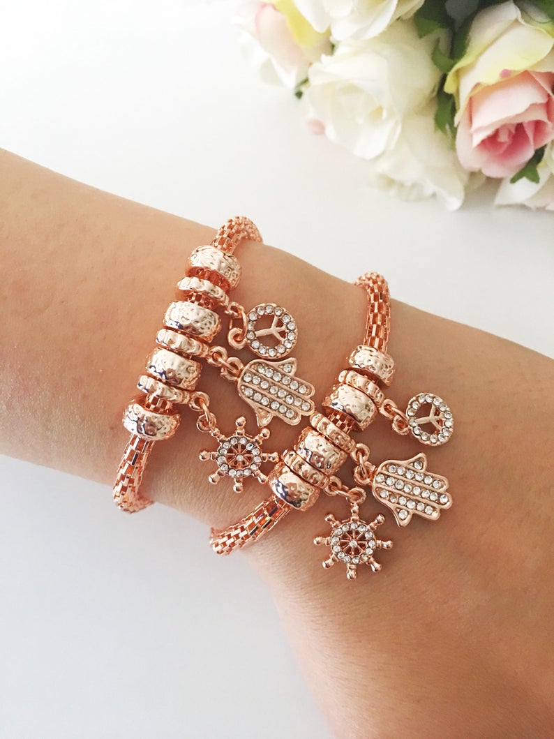 Hamsa Charm Bracelet featuring zirconia stones, available in rose gold, gold, and silver, showcasing adjustable design and 7 unique charms.