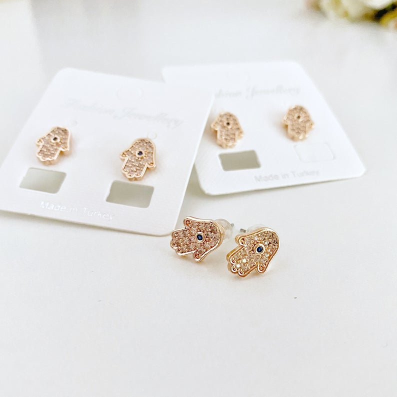 A pair of handmade Hamsa earrings featuring zircon stones, available in silver and rose gold, symbolizing protection and good luck.
