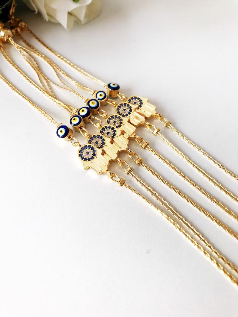A beautiful handmade Hamsa Evil Eye Bracelet featuring a gold chain, hamsa charm, and evil eye beads, symbolizing protection and good fortune.