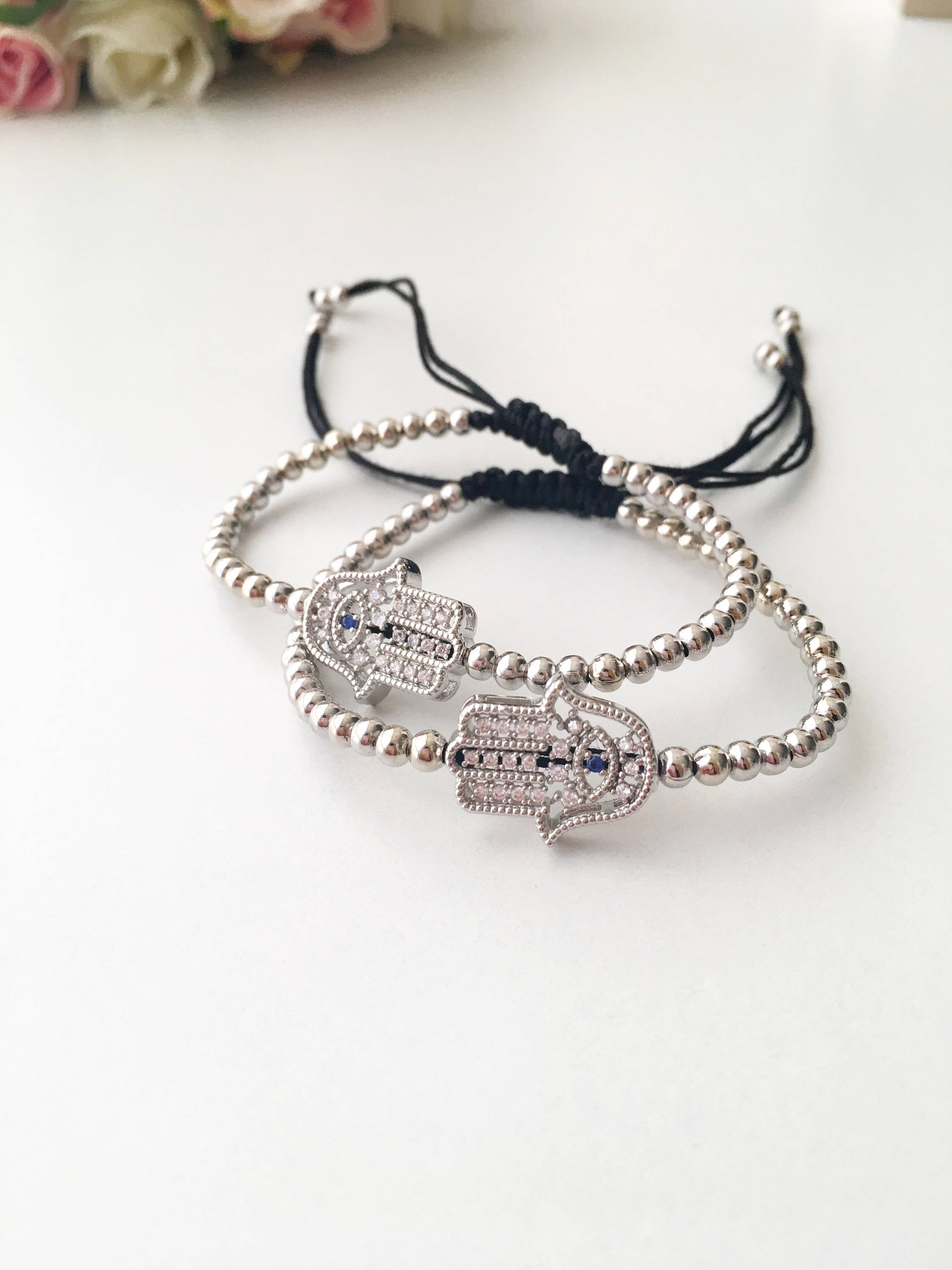 A beautiful Hamsa Hand Bracelet in rose gold and silver, featuring sparkling zirconia stones and an adjustable design for a perfect fit.