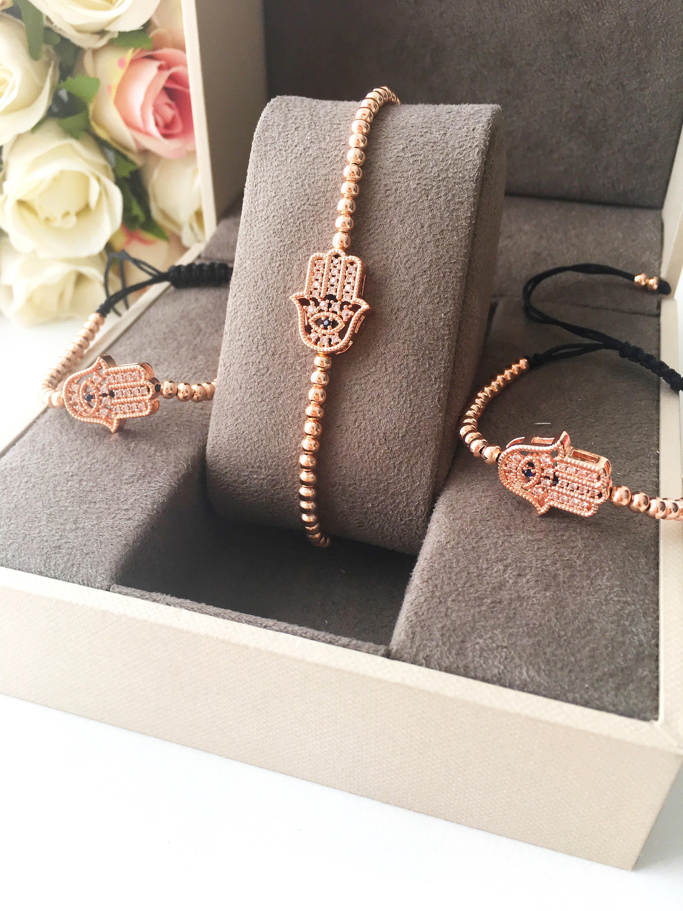 A beautiful Hamsa Hand Bracelet in rose gold and silver, featuring sparkling zirconia stones and an adjustable design for a perfect fit.