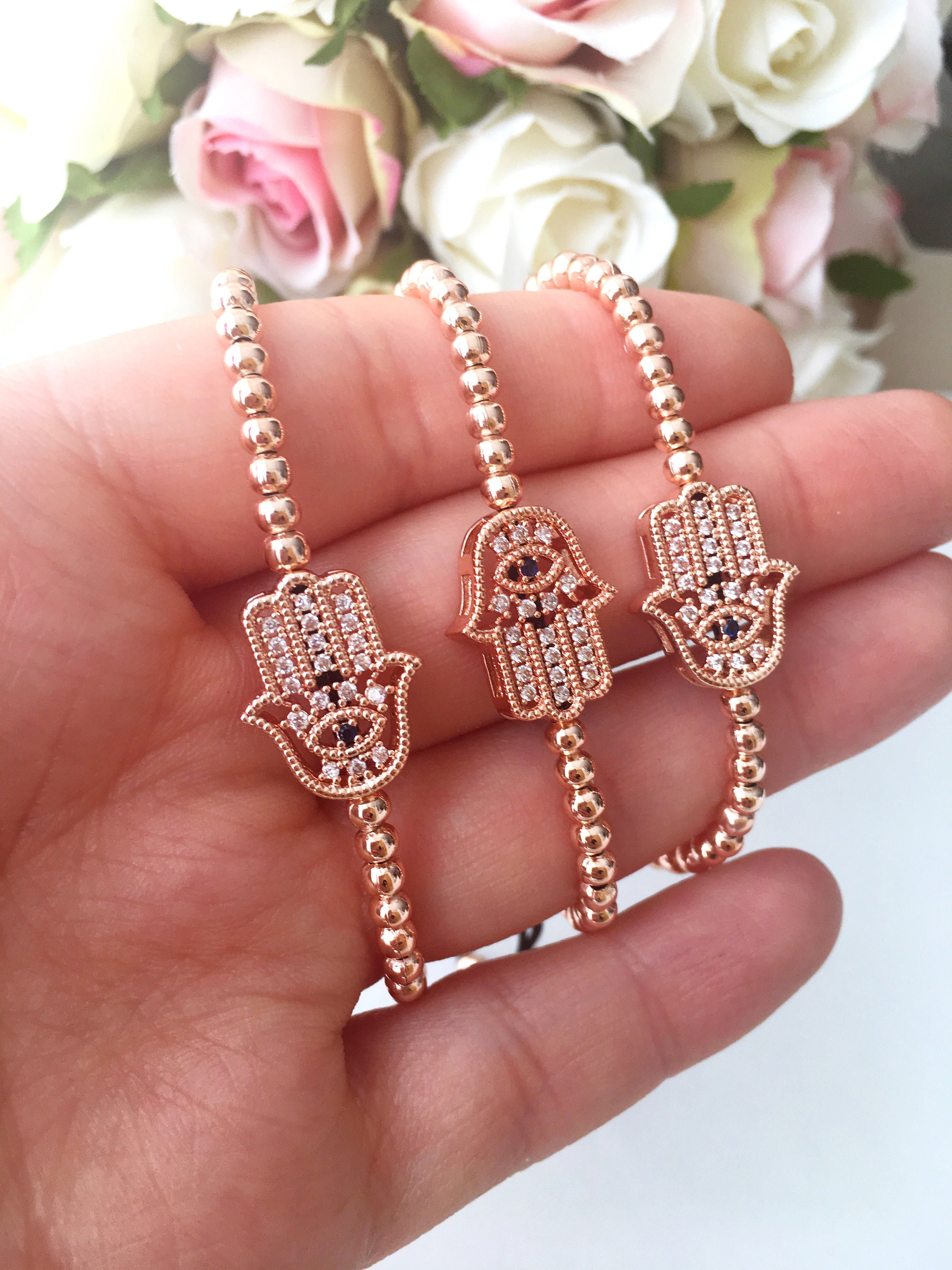 A beautiful Hamsa Hand Bracelet in rose gold and silver, featuring sparkling zirconia stones and an adjustable design for a perfect fit.