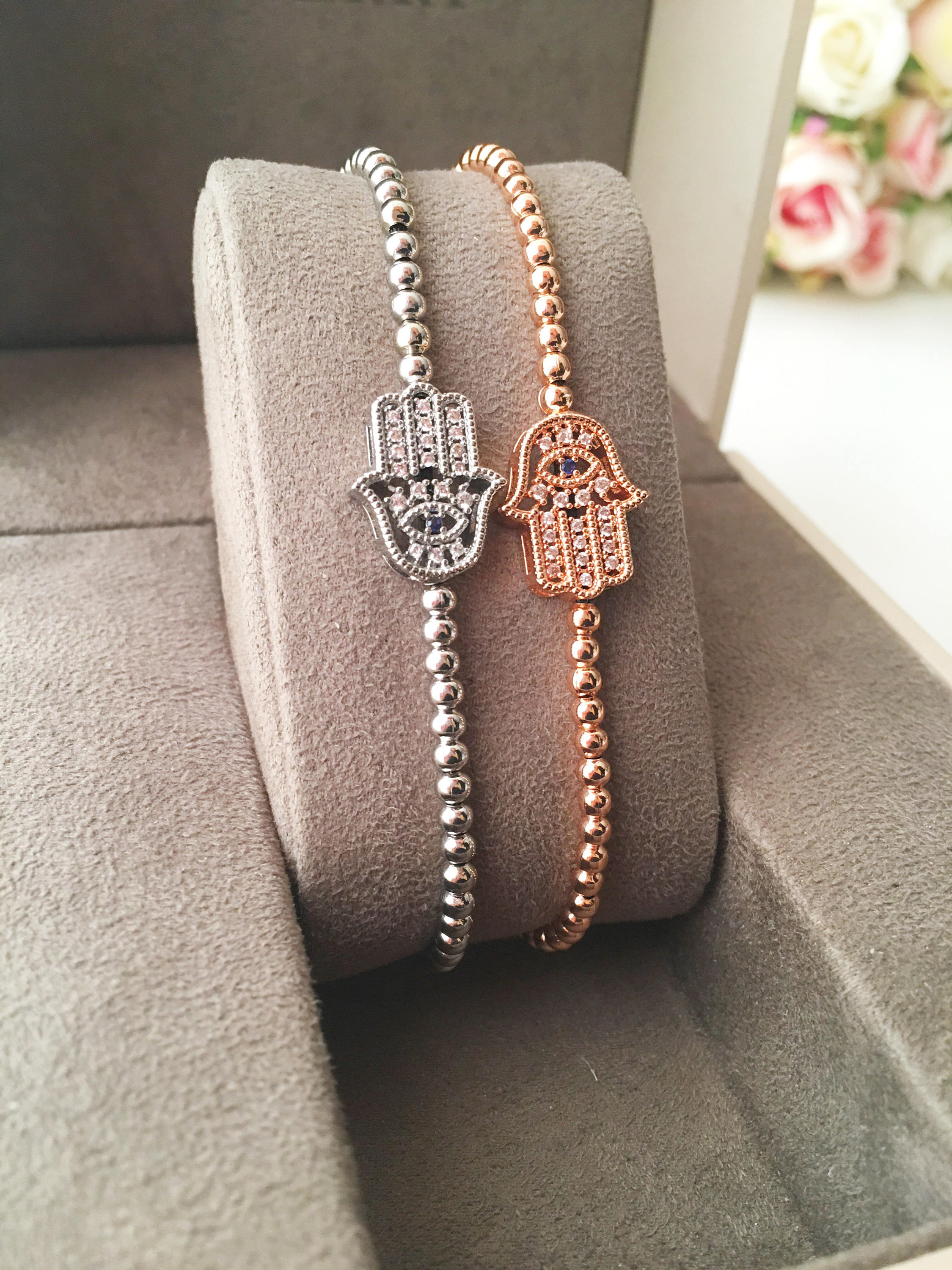 A beautiful Hamsa Hand Bracelet in rose gold and silver, featuring sparkling zirconia stones and an adjustable design for a perfect fit.
