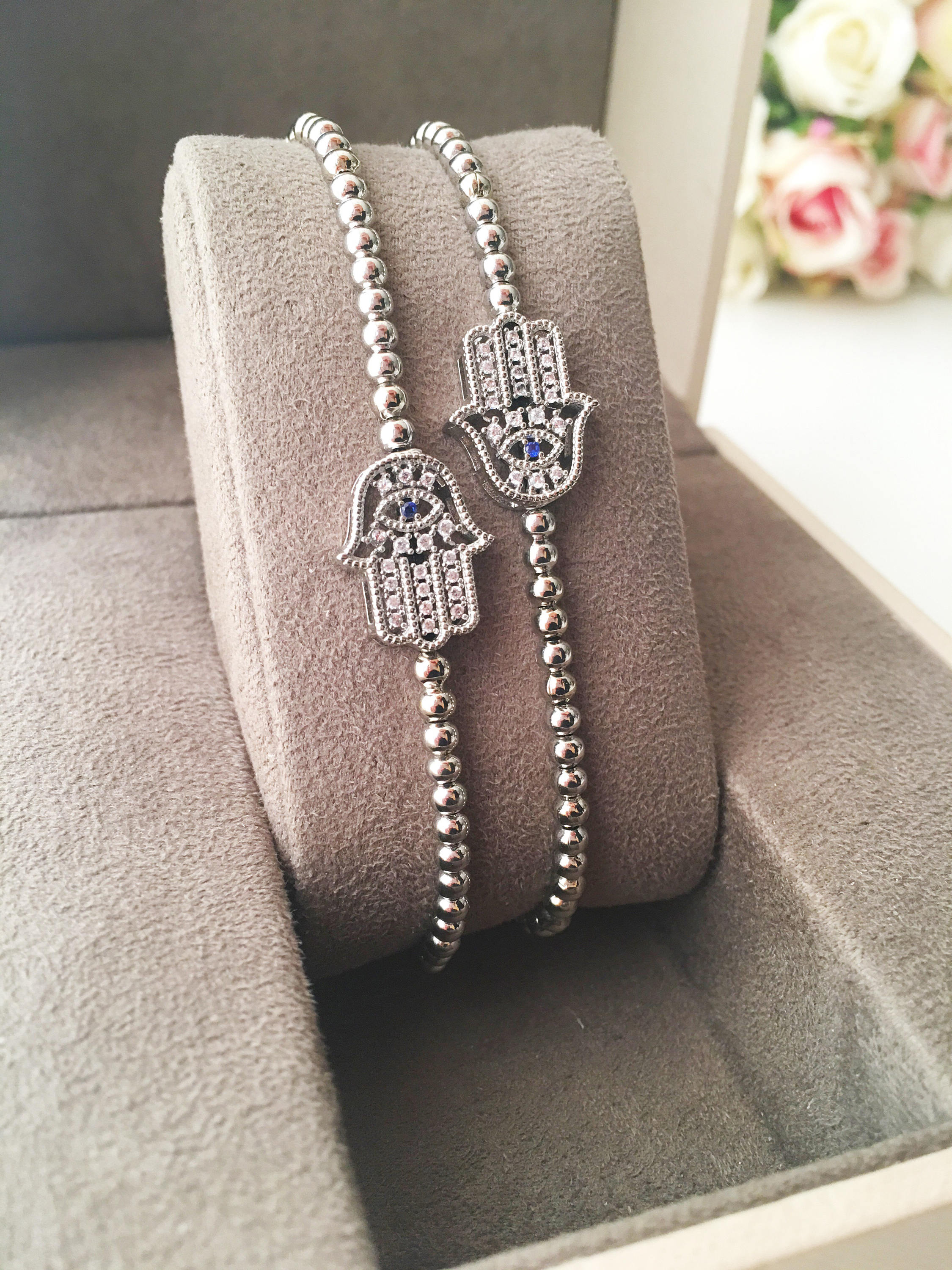 A beautiful Hamsa Hand Bracelet in rose gold and silver, featuring sparkling zirconia stones and an adjustable design for a perfect fit.