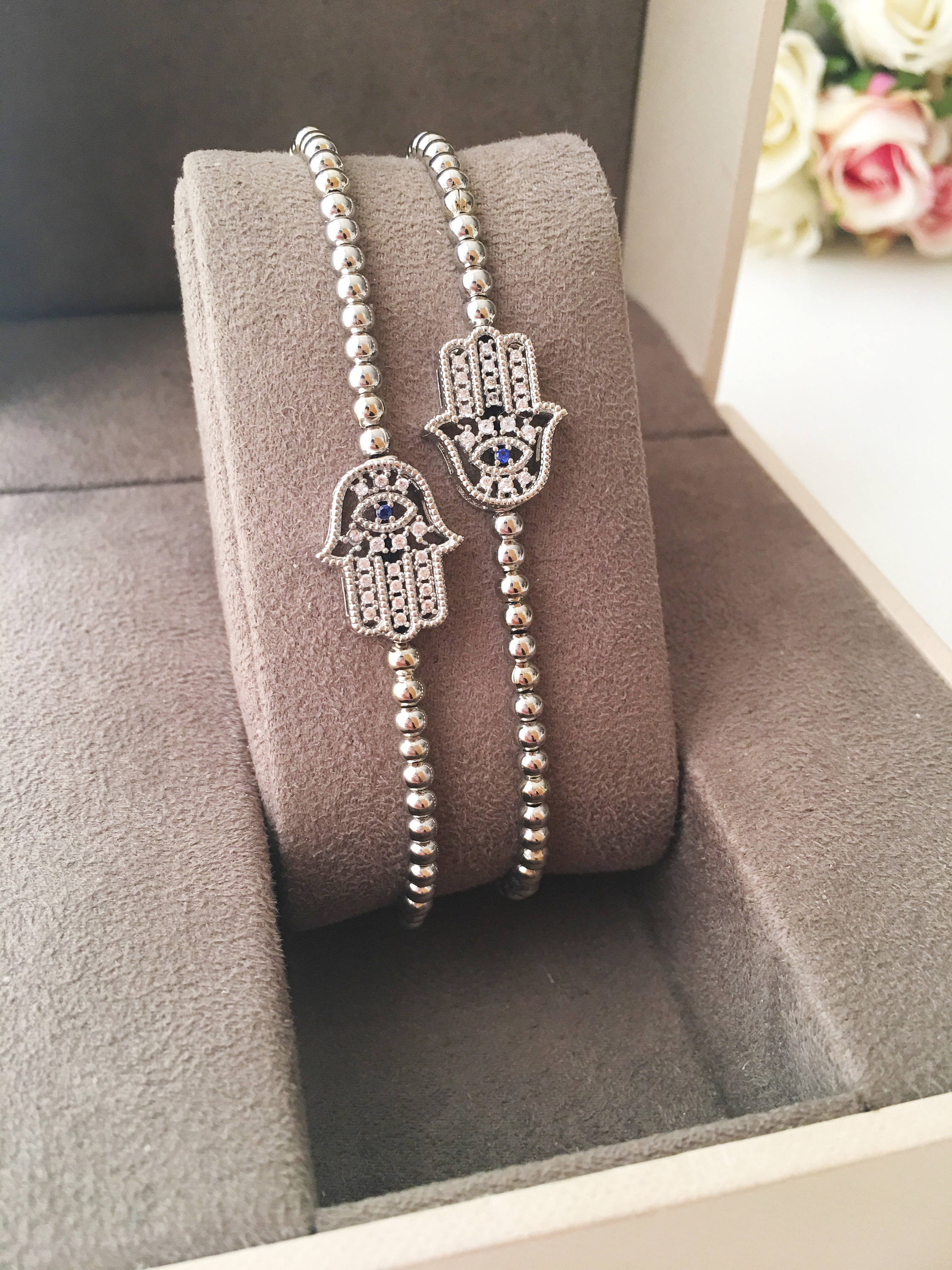 A beautiful Hamsa Hand Bracelet in rose gold and silver, featuring sparkling zirconia stones and an adjustable design for a perfect fit.