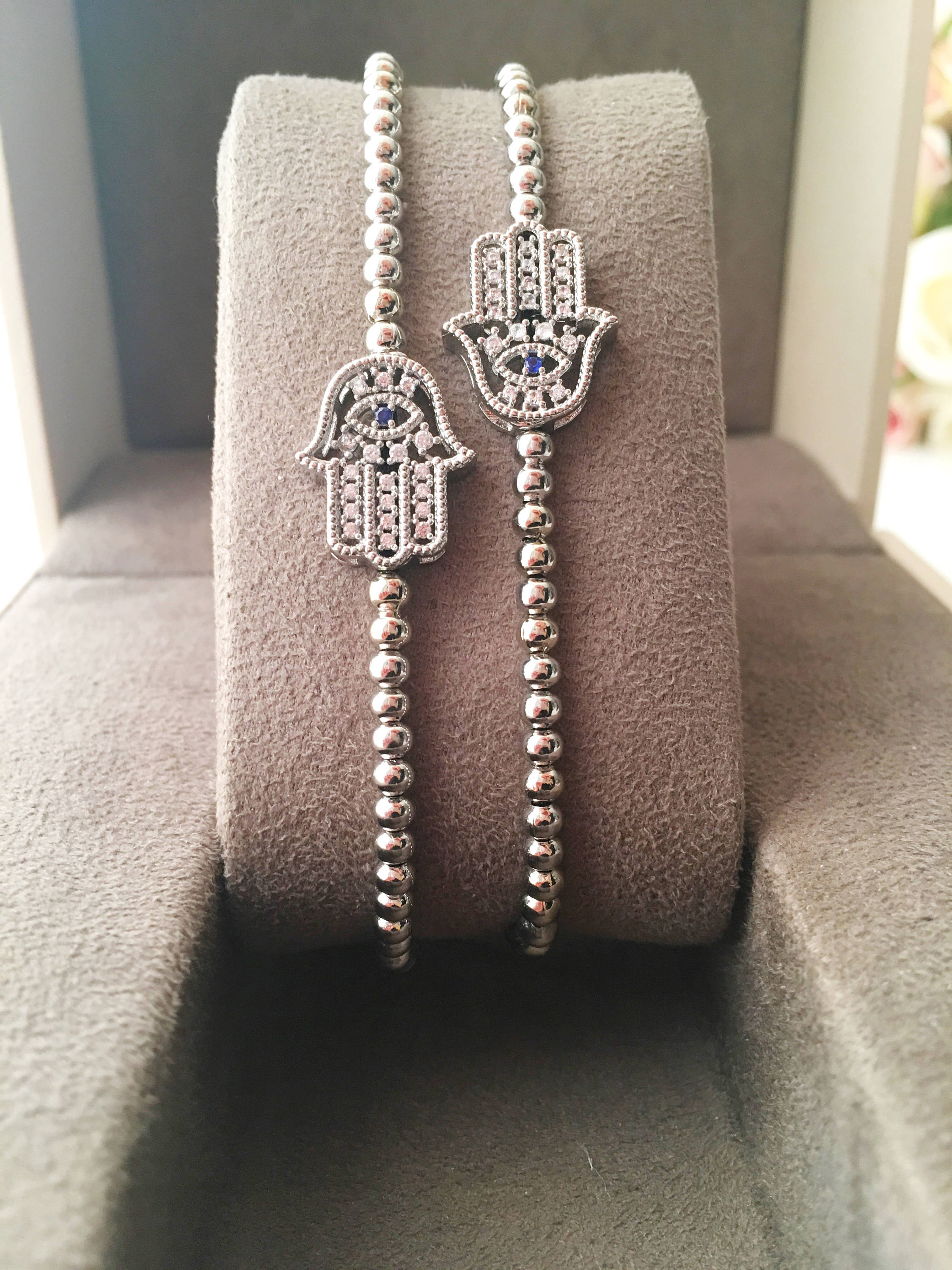 A beautiful Hamsa Hand Bracelet in rose gold and silver, featuring sparkling zirconia stones and an adjustable design for a perfect fit.