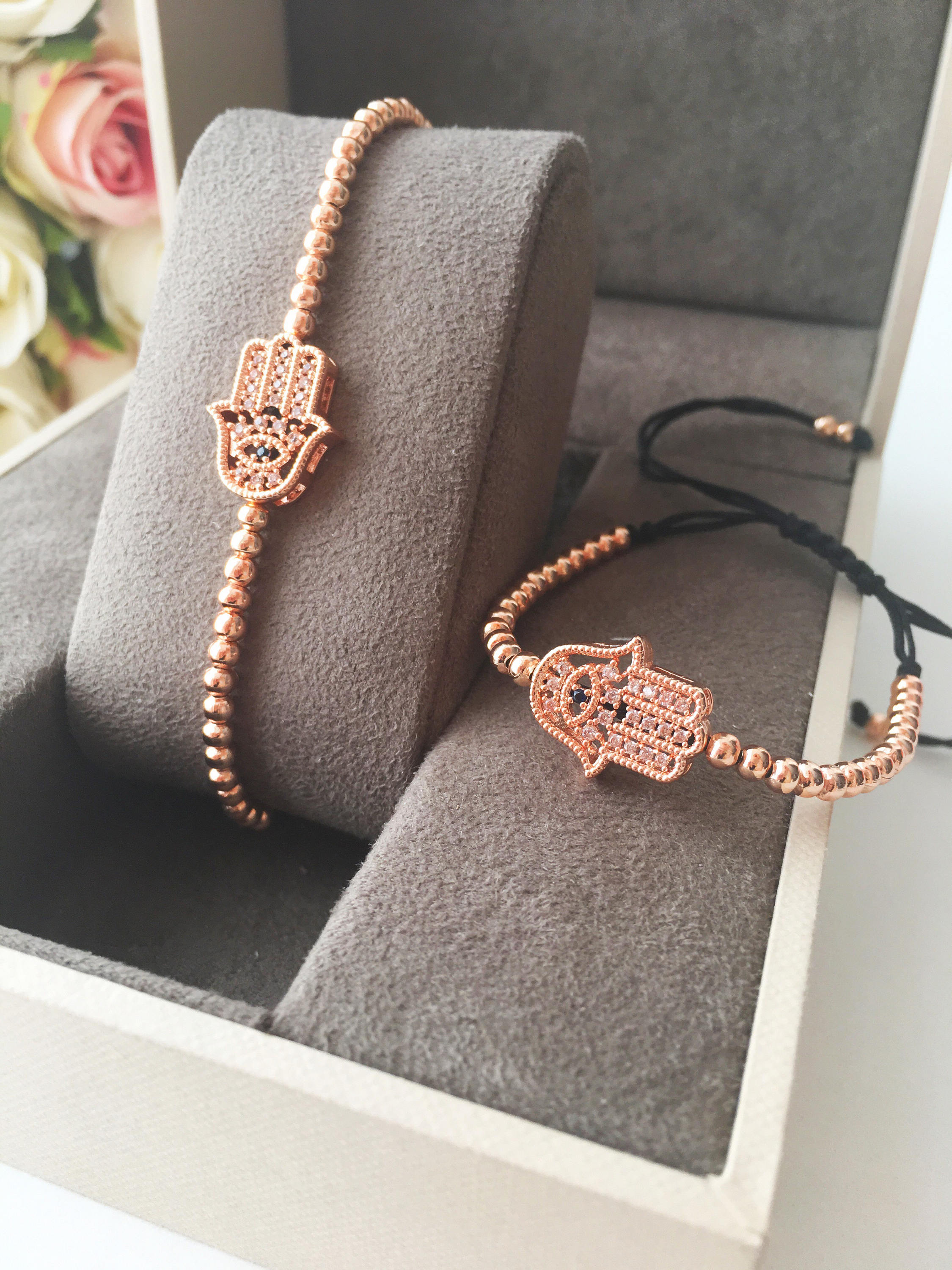 A beautiful Hamsa Hand Bracelet in rose gold and silver, featuring sparkling zirconia stones and an adjustable design for a perfect fit.
