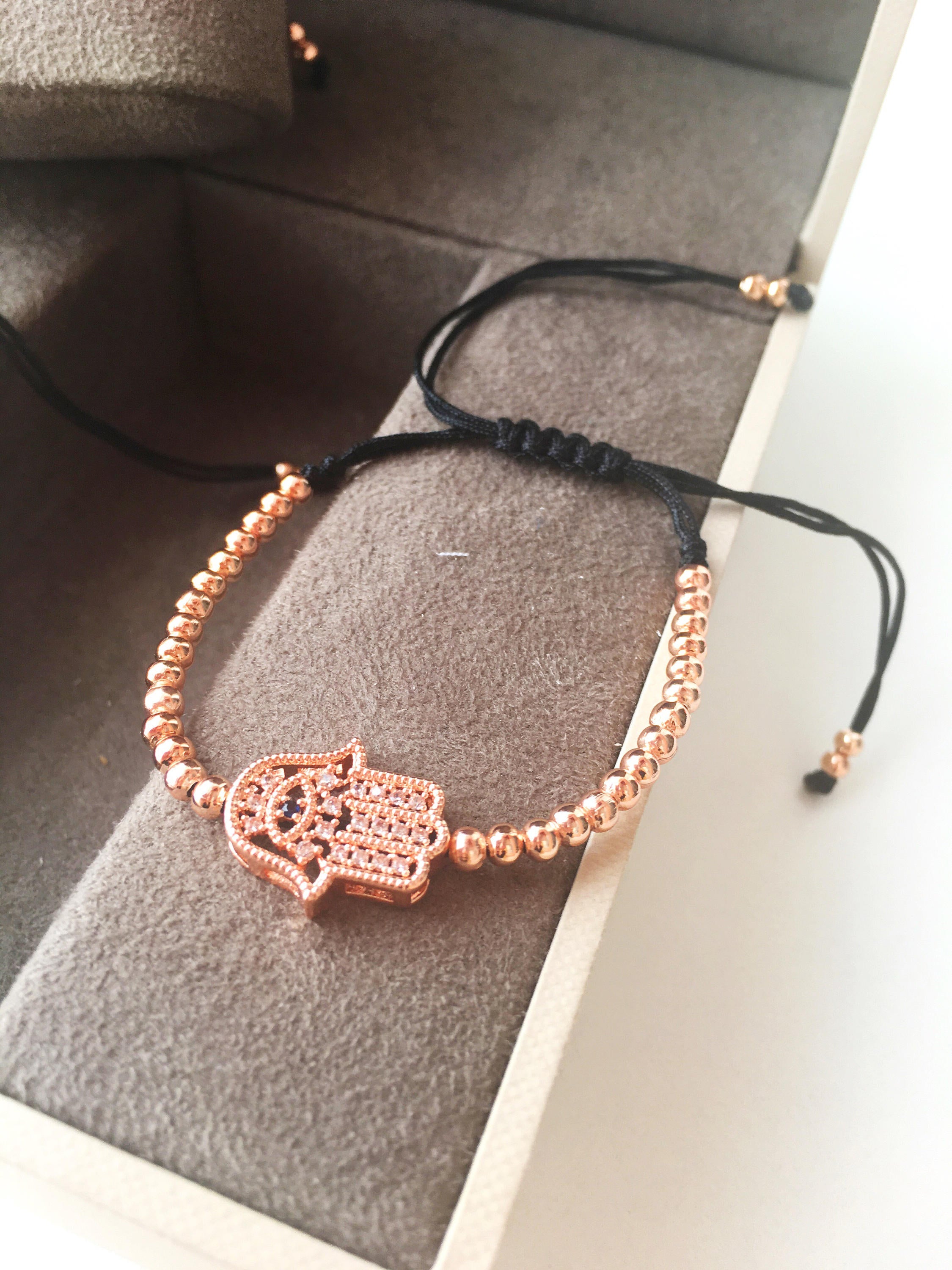 A beautiful Hamsa Hand Bracelet in rose gold and silver, featuring sparkling zirconia stones and an adjustable design for a perfect fit.