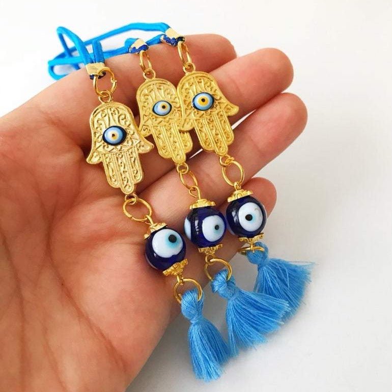 A beautifully crafted Hamsa hand evil eye car mirror charm featuring vibrant blue glass beads, symbolizing protection and good luck.