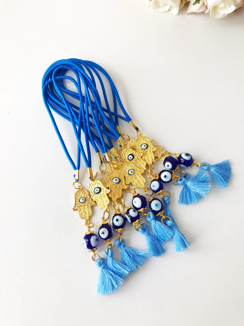 A beautifully crafted Hamsa hand evil eye car mirror charm featuring vibrant blue glass beads, symbolizing protection and good luck.
