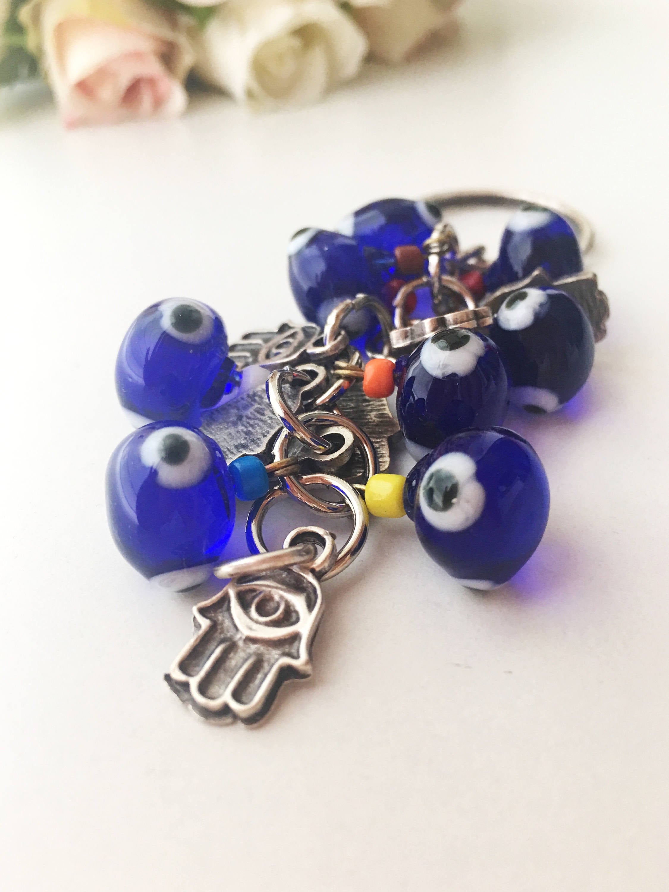 A beautifully crafted Hamsa keychain featuring a blue glass evil eye bead, symbolizing protection and good luck.