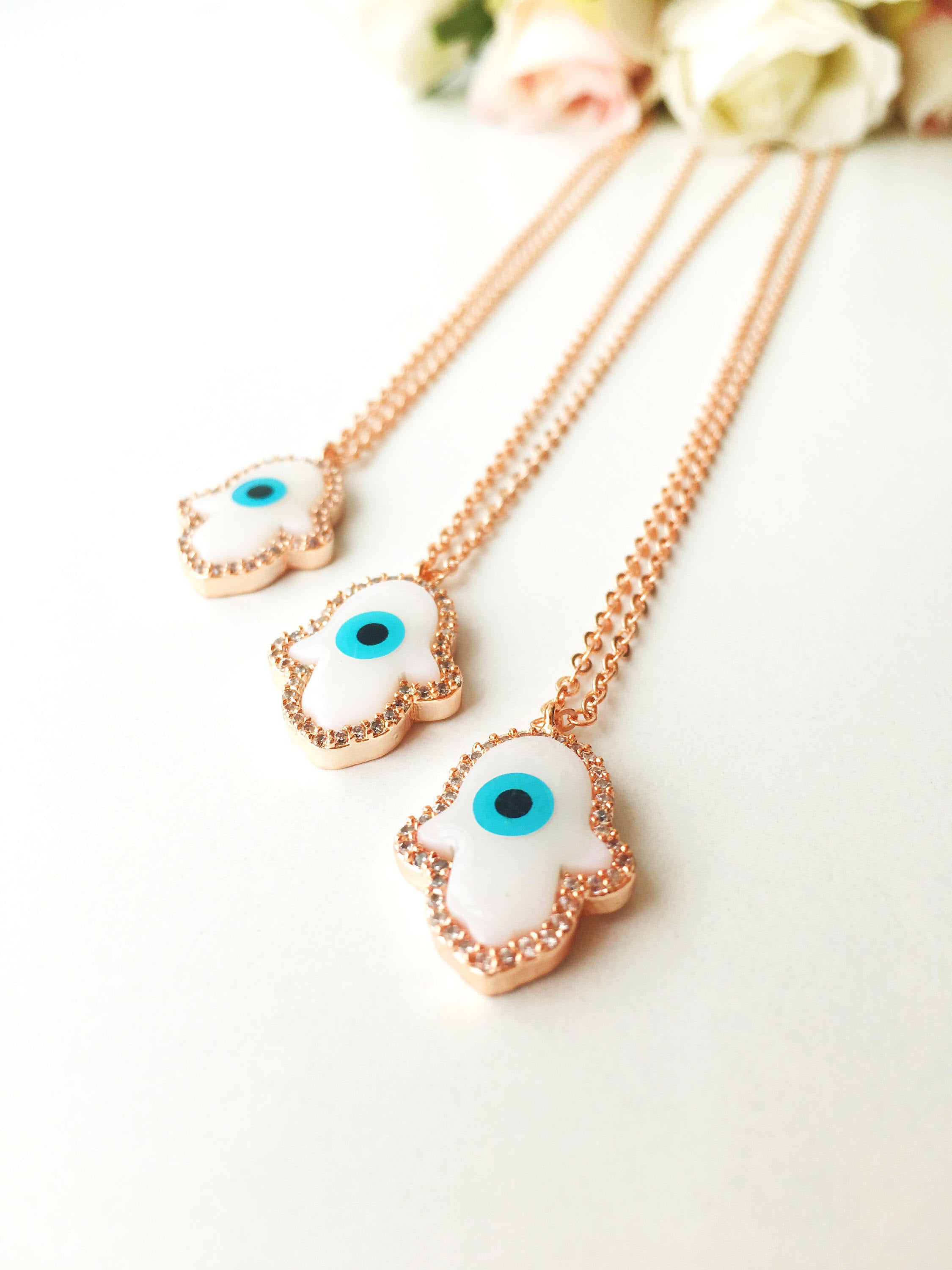 Handmade rose gold Hamsa necklace with evil eye bracelet, featuring mother of pearl details.