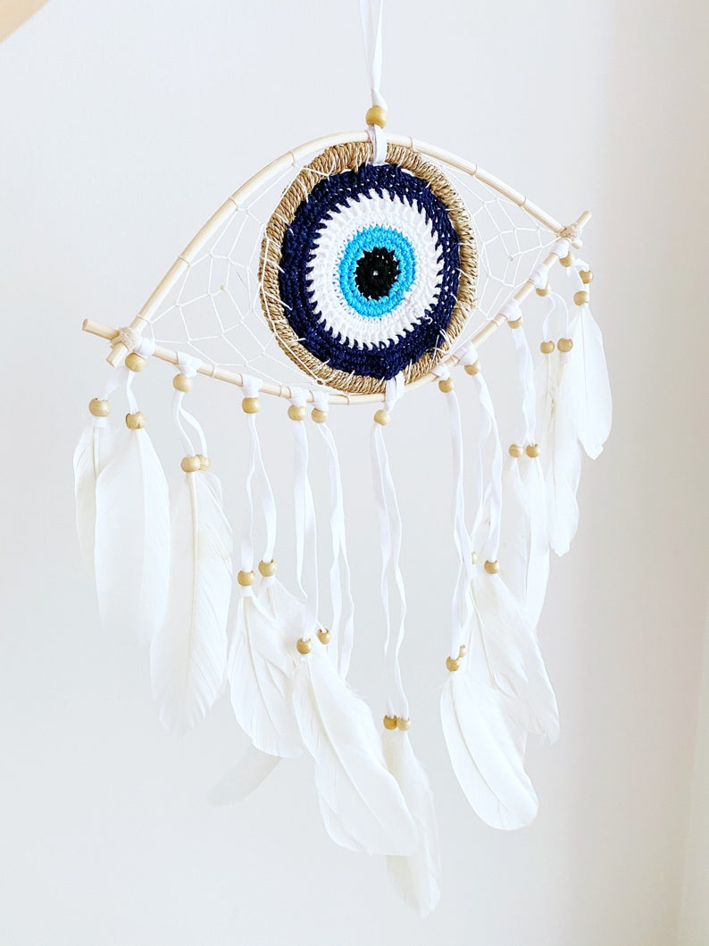 Handmade Evil Eye Dream Catcher featuring blue evil eye design, feathers, and bamboo frame, perfect for home decor and protection.