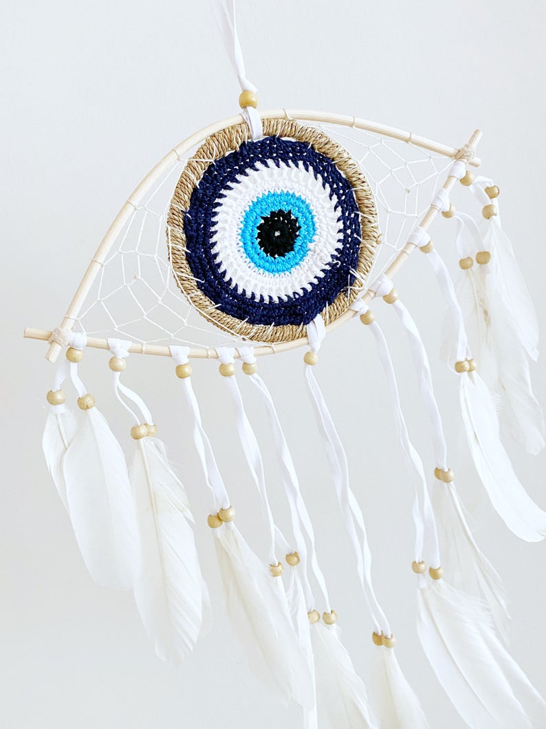 Handmade Evil Eye Dream Catcher featuring blue evil eye design, feathers, and bamboo frame, perfect for home decor and protection.
