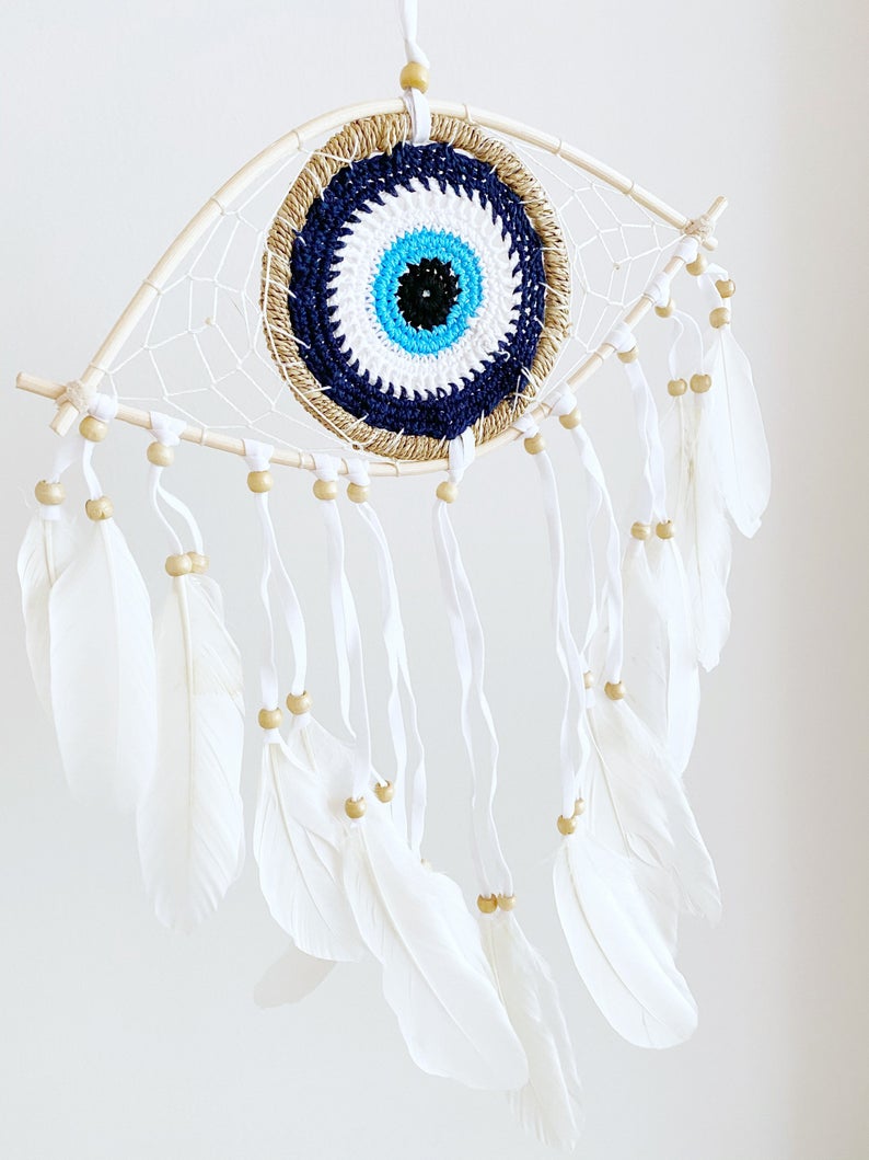 Handmade Evil Eye Dream Catcher featuring blue evil eye design, feathers, and bamboo frame, perfect for home decor and protection.