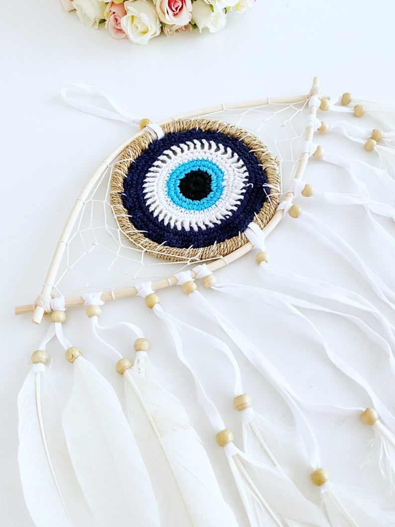 Handmade Evil Eye Dream Catcher featuring blue evil eye design, feathers, and bamboo frame, perfect for home decor and protection.