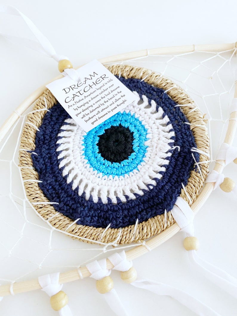 Handmade Evil Eye Dream Catcher featuring blue evil eye design, feathers, and bamboo frame, perfect for home decor and protection.