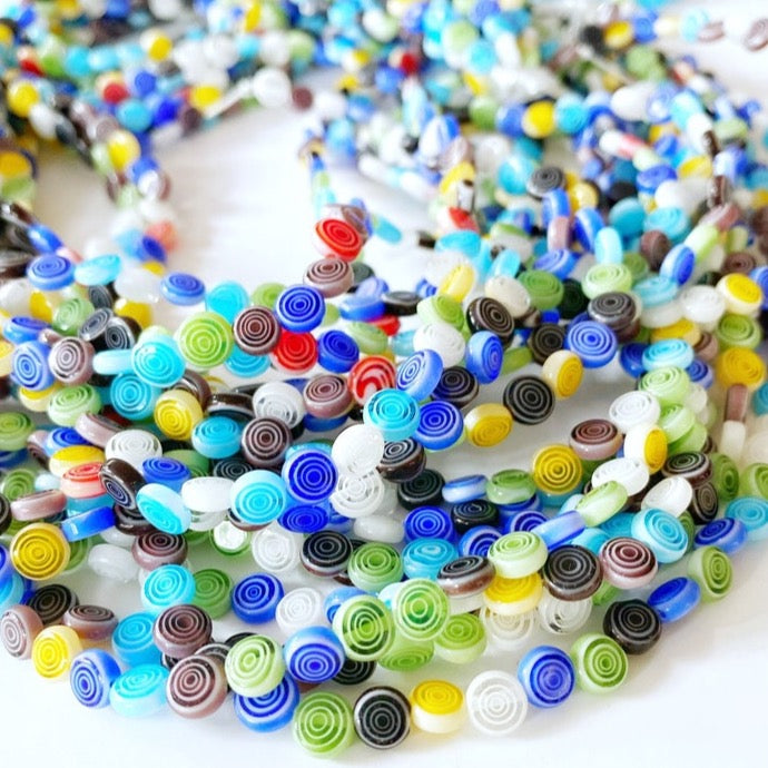 A collection of 60 handmade flat round millefiori beads in assorted colors, featuring a circular floral design, perfect for DIY jewelry making.