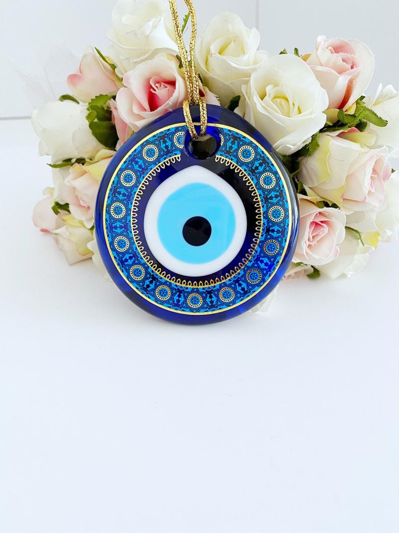 A beautifully crafted handmade glass evil eye bead, featuring intricate patterns and a vibrant blue color, symbolizing protection and good fortune.