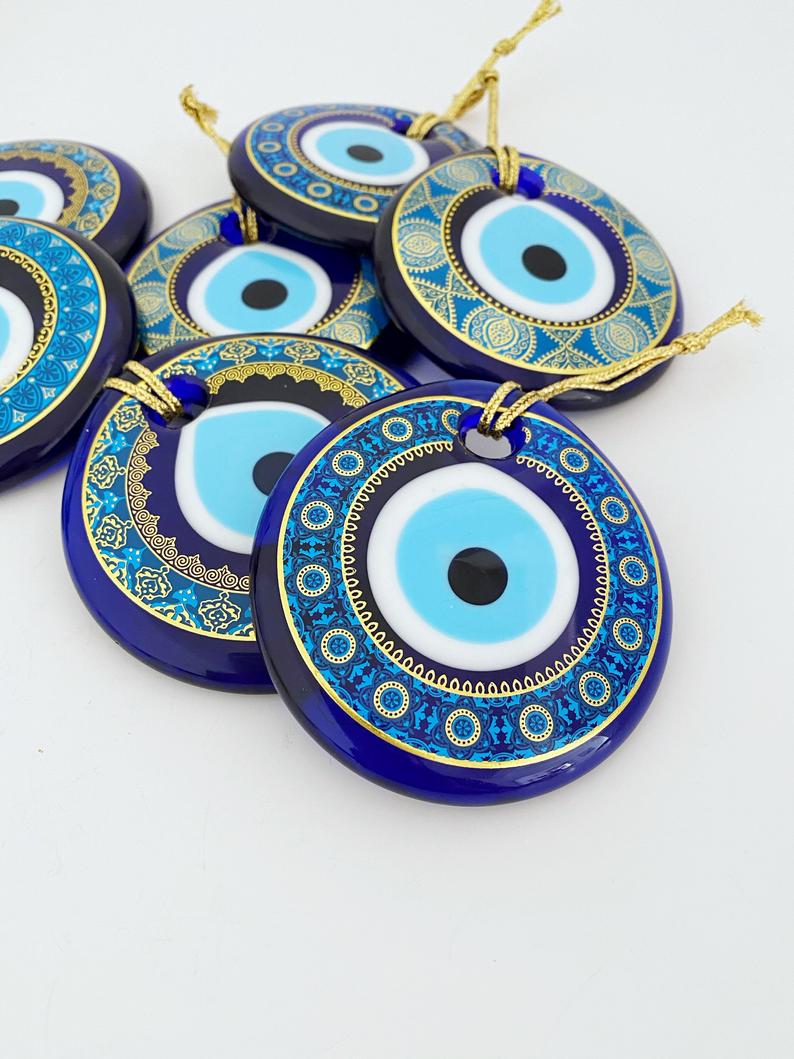 A beautifully crafted handmade glass evil eye bead, featuring intricate patterns and a vibrant blue color, symbolizing protection and good fortune.