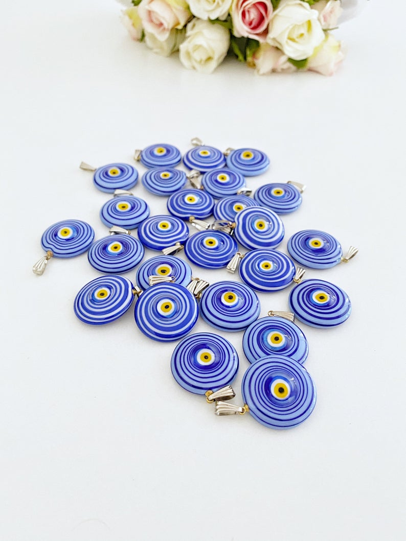 Handmade Murano bead featuring a blue evil eye charm, showcasing intricate glasswork and vibrant color.