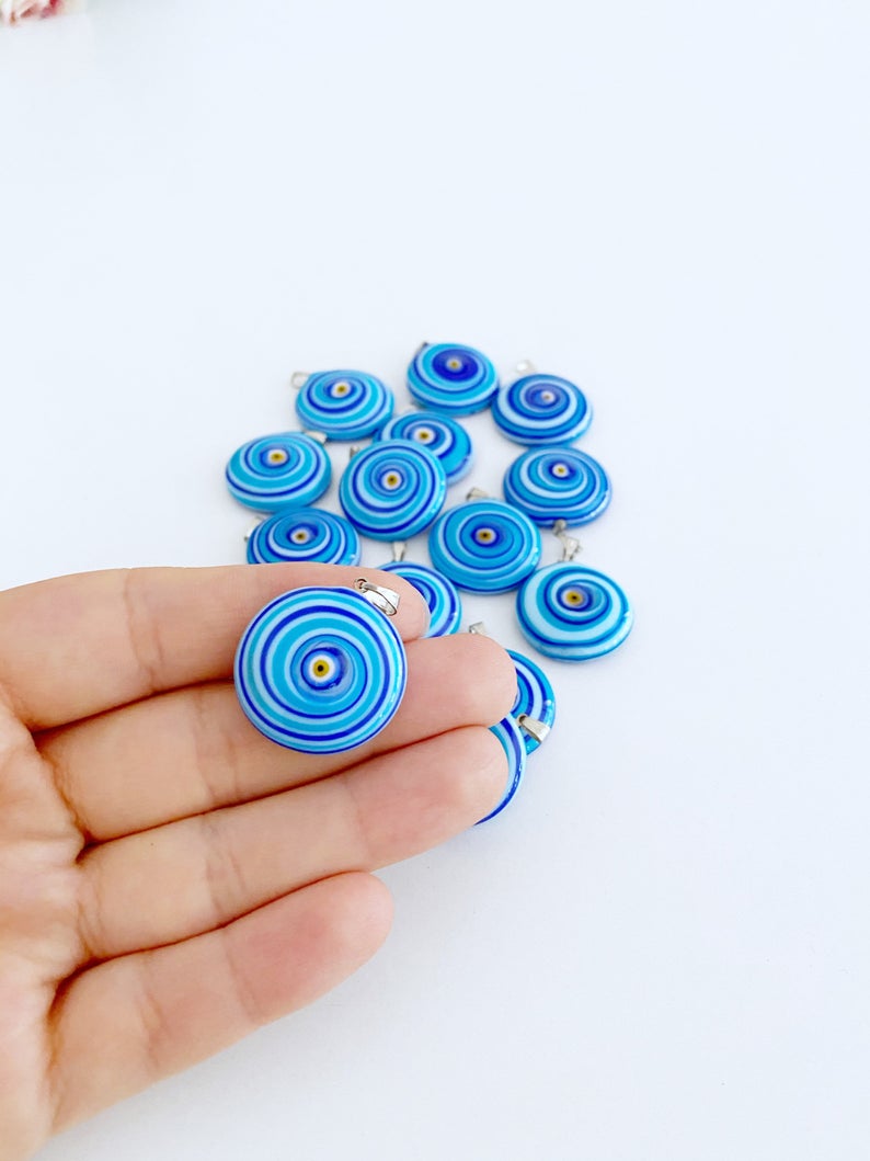Handmade Murano bead featuring a blue evil eye charm, showcasing intricate glasswork and vibrant color.