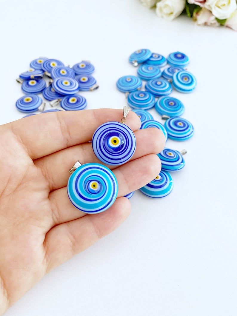 Handmade Murano bead featuring a blue evil eye charm, showcasing intricate glasswork and vibrant color.