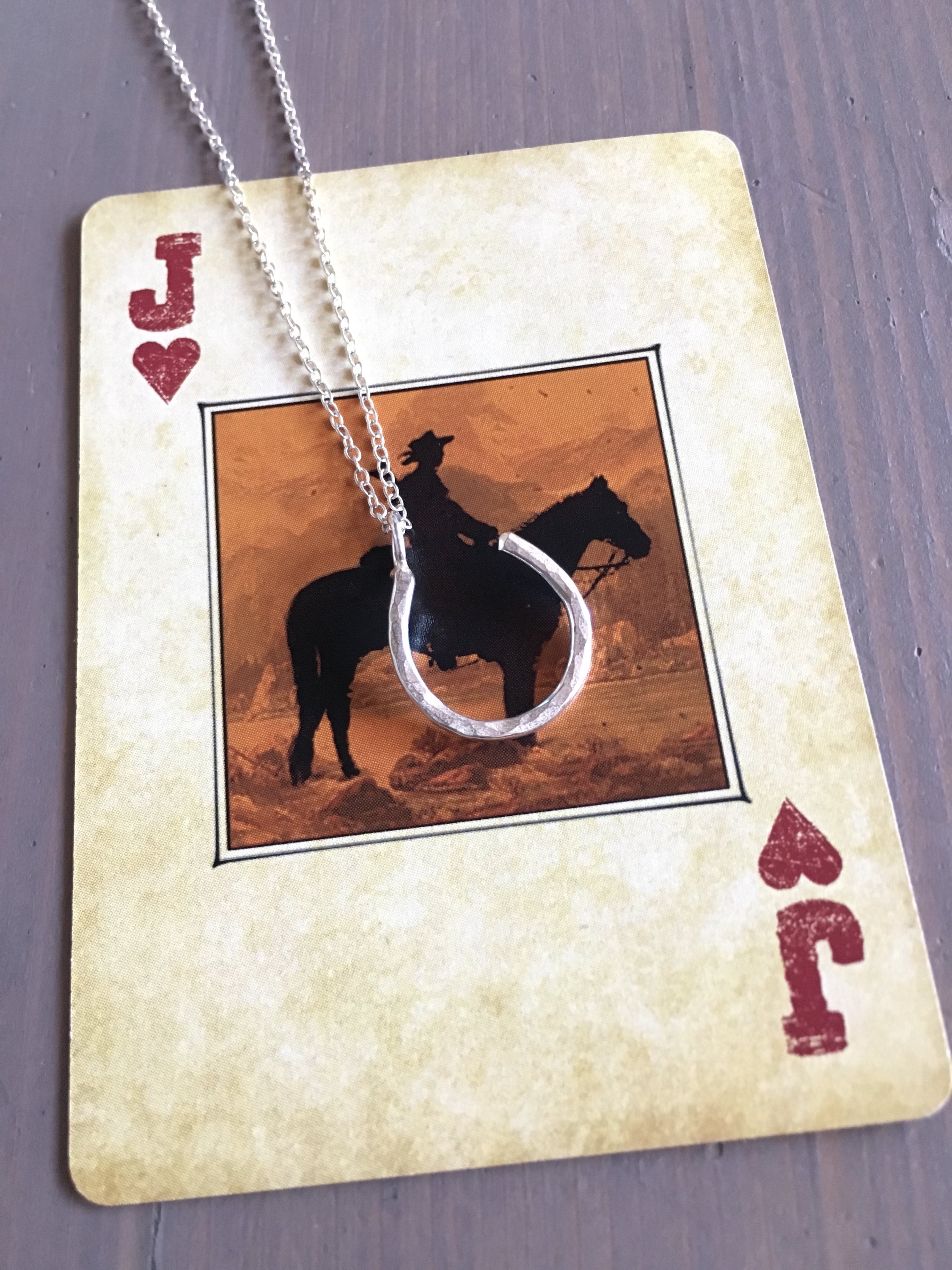 A delicate Hanging Lucky Horseshoe Charm Necklace featuring a hammered horseshoe pendant in sterling silver, yellow gold fill, or rose gold fill.