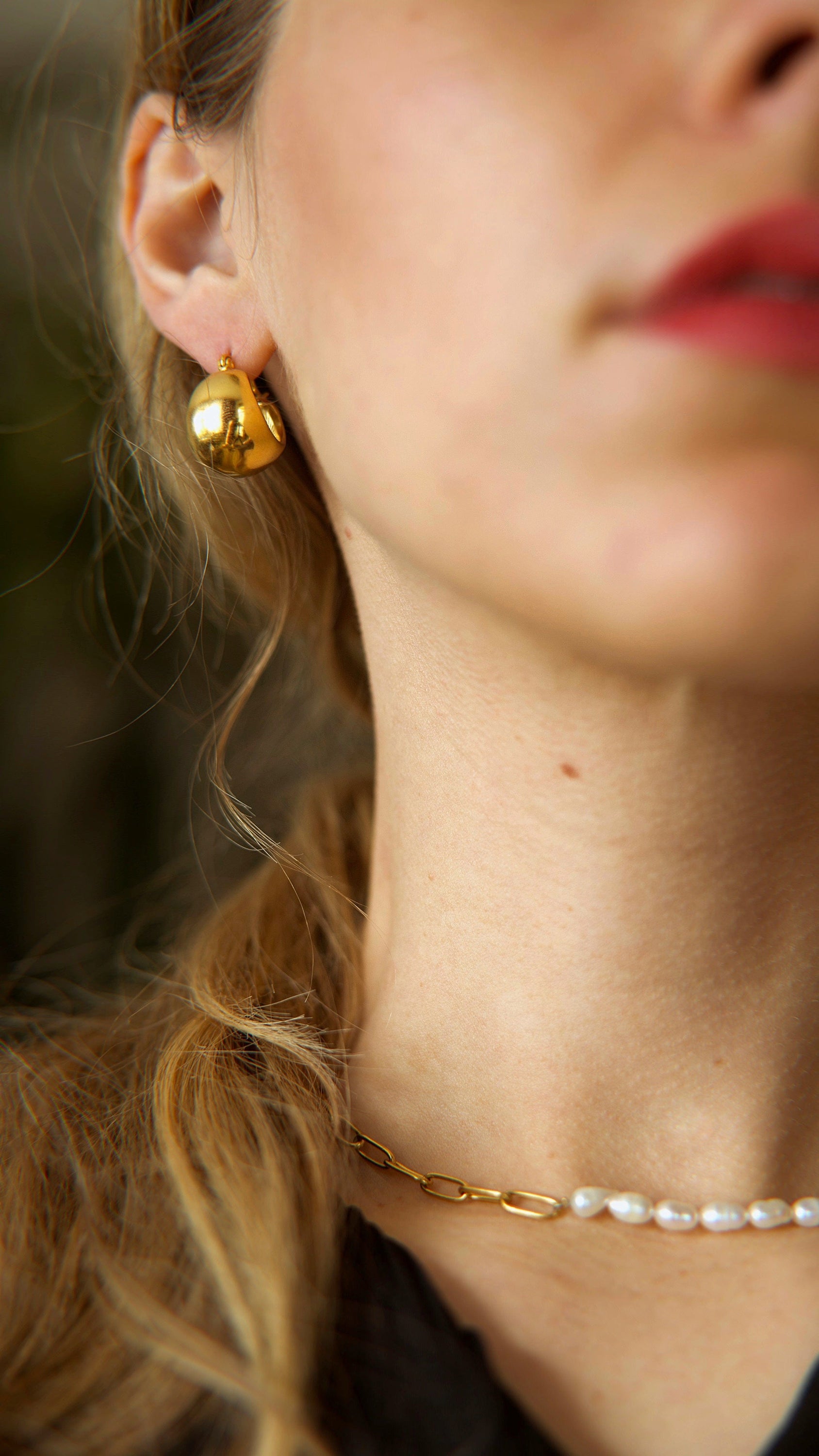 A pair of Hazel ball hoop earrings made from stainless steel with 18Kt yellow gold PVD plating, showcasing a unique and bold design.