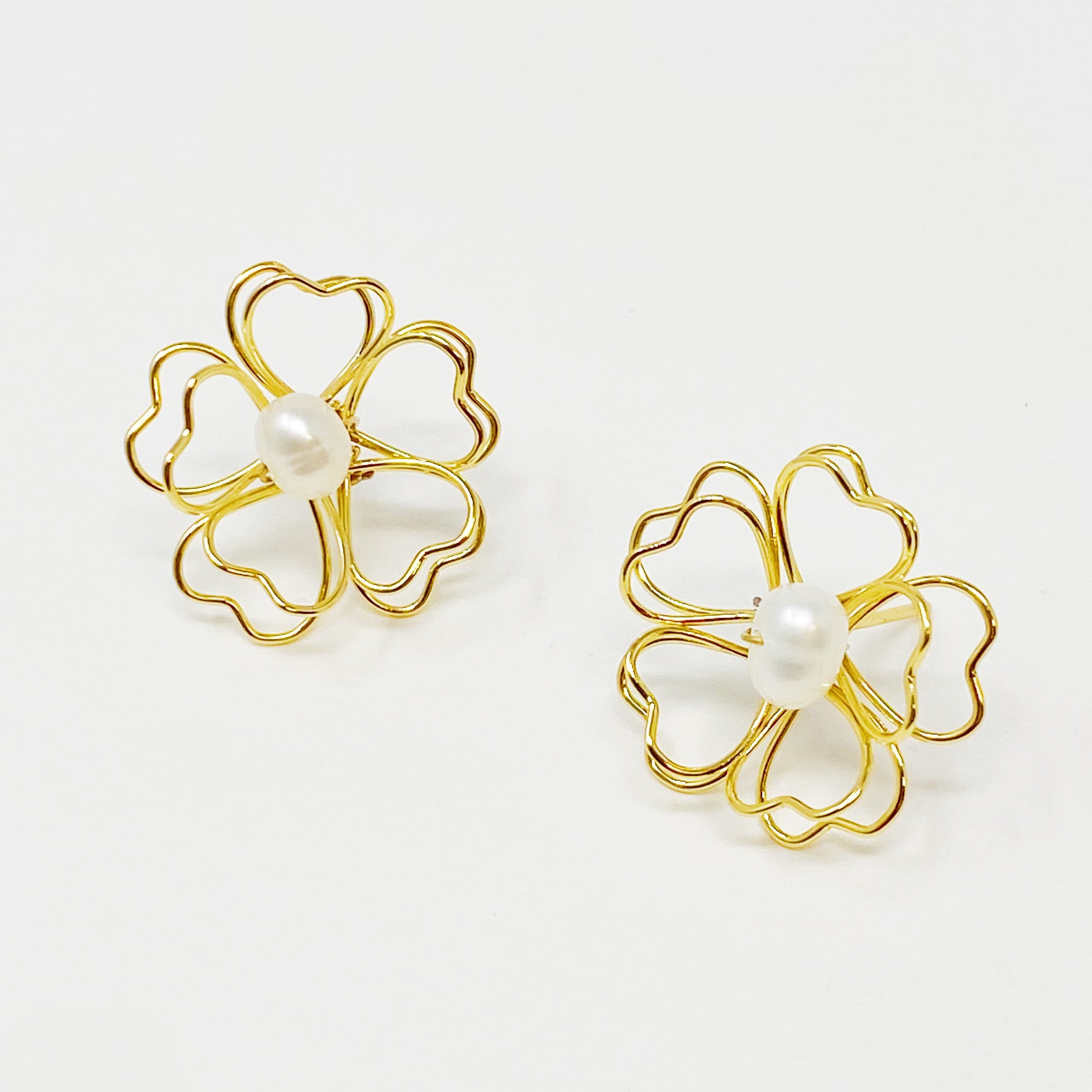 Elegant Heart Petals earrings featuring a freshwater pearl centerpiece and golden wire design.